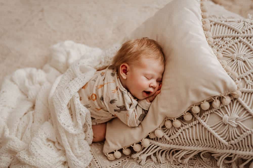 Schlafendes Baby auf einem Kissen mit langen roten Haaren