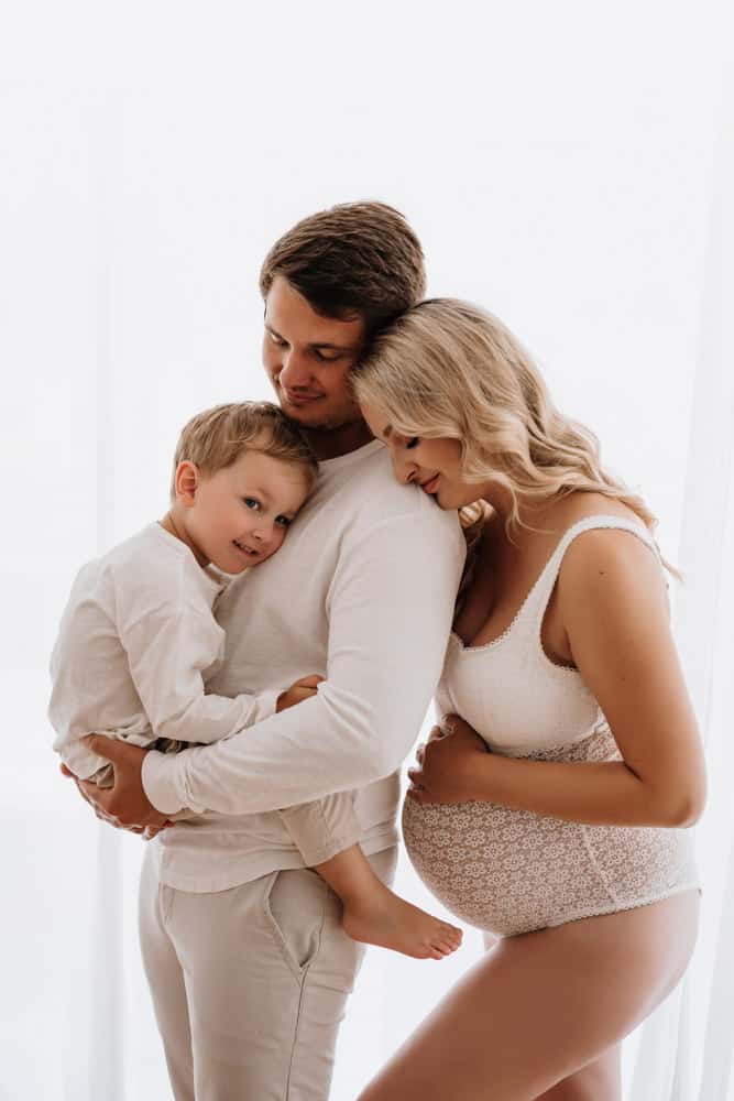 Eltern mit Kind, die Frau ist schwanger und träge Dessous.