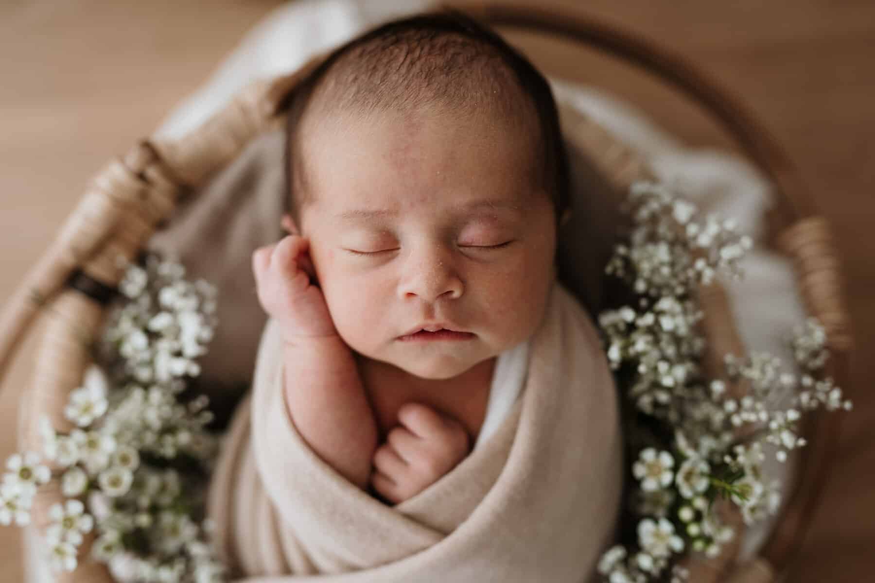 Baby in Korb mit Blumen