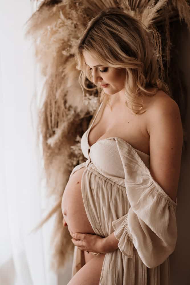 Schwangere in Kleid, das am Bauch geöffnet ist