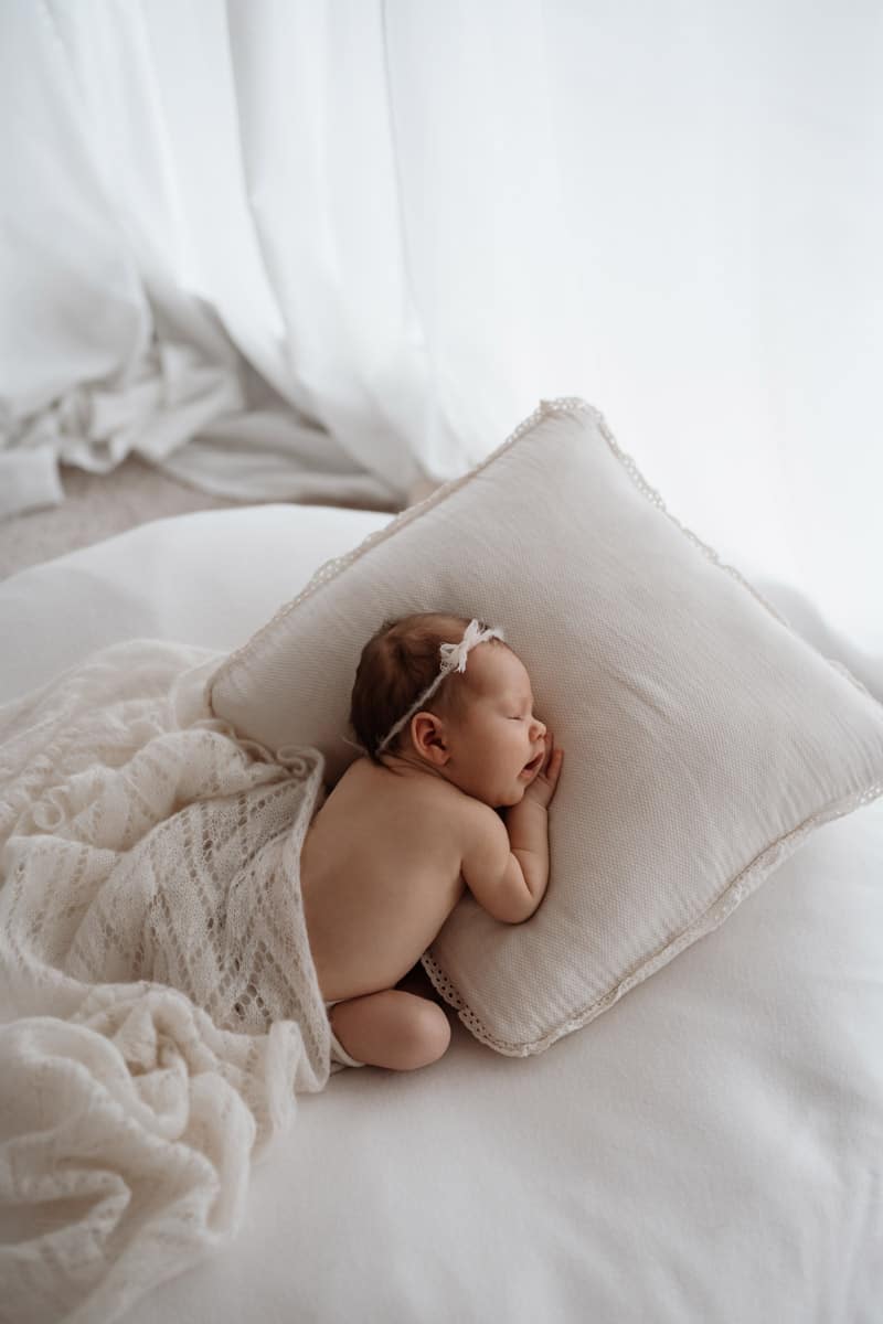 Baby kuschelt auf Kissen