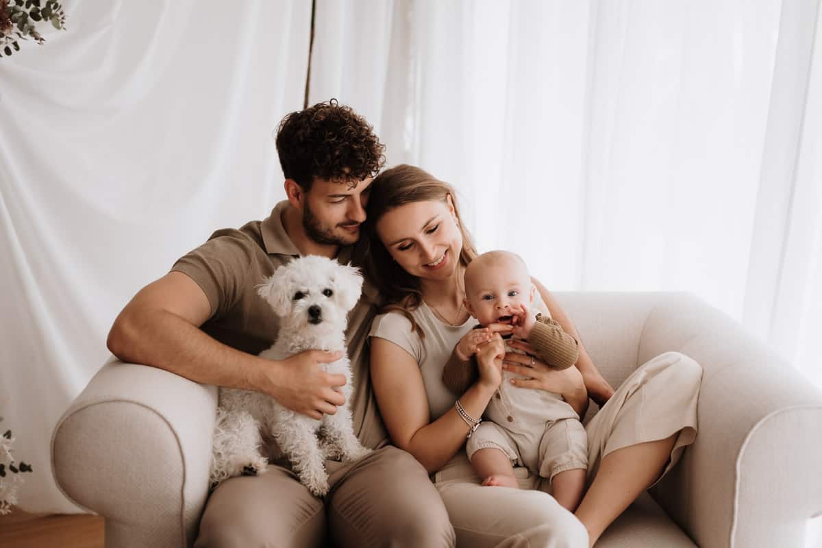 Eltern mit Kind und Hund auf dem Sofa