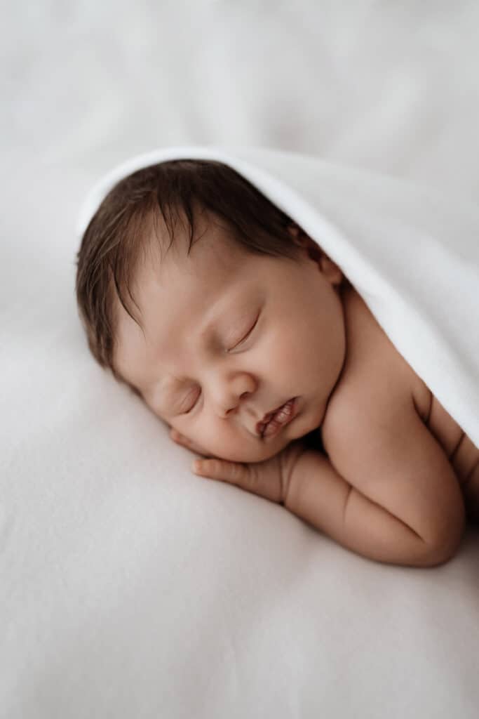 Baby kuschelt auf Decke
