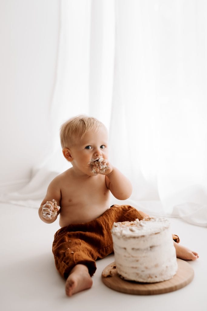 Ein Kleinkind isst eine Torte mit den Händen