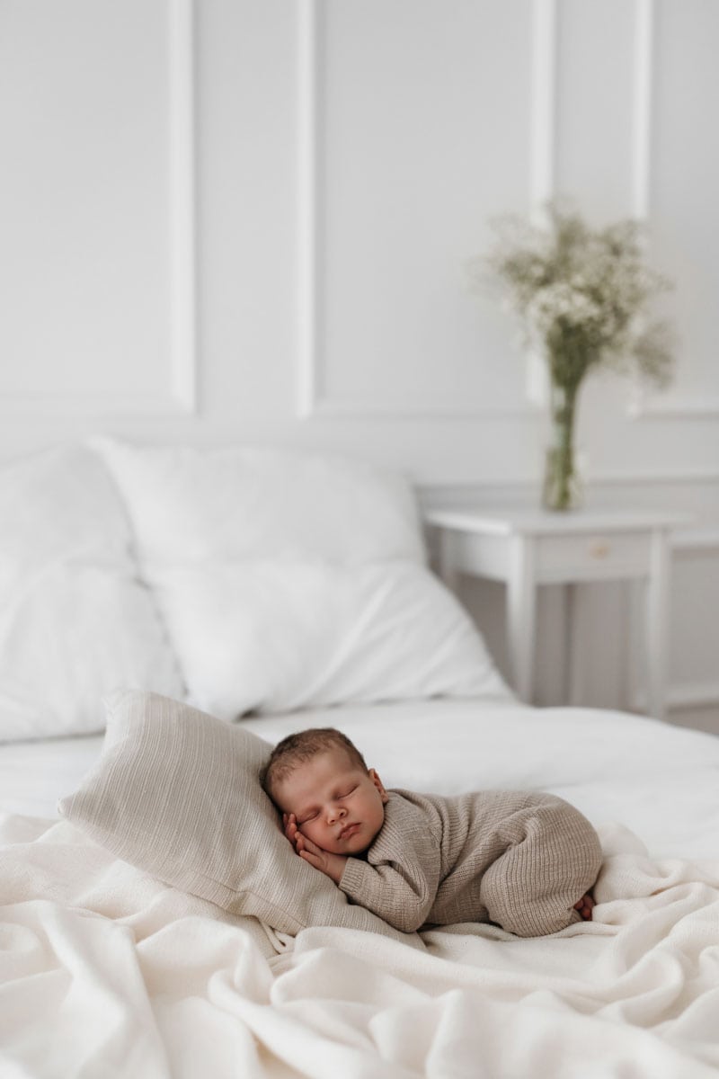 Baby liegt auf dem Bett