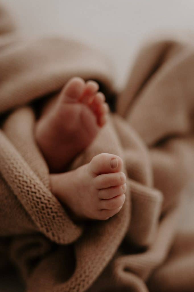 Neugeborene Babyfüße eingewickelt in eine weiche Decke im Fotostudio Göttingen.
